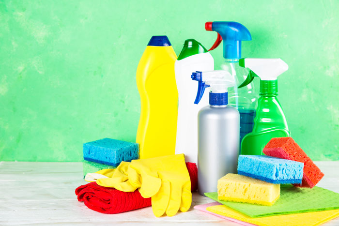 Cleaning product, household on green background.